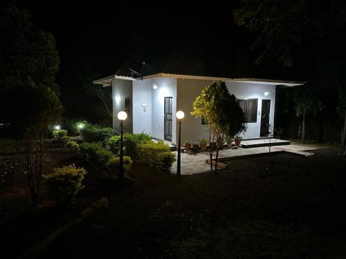 a small white house at night with two lights at Maro Homestay Sango in Old Moshi