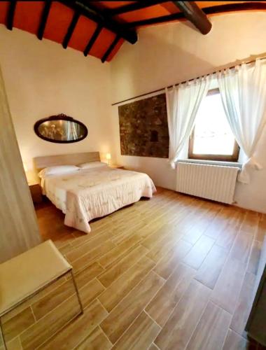 a bedroom with a bed and a large window at Podere San Antonio Scopeta in Querceto