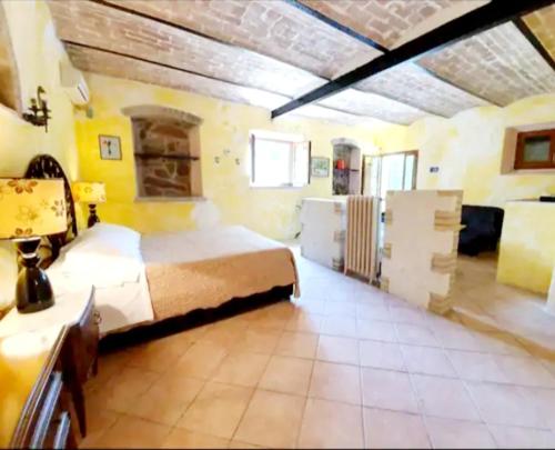 a large bedroom with a large bed and a room with yellow walls at Podere San Antonio Scopeta in Querceto