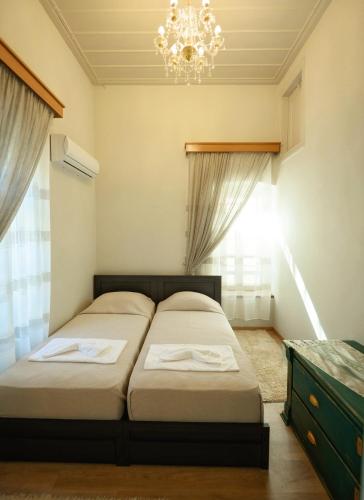 a bedroom with two beds and a chandelier at STEMA Kalymnos in Kalymnos