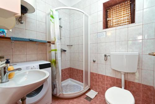een badkamer met douche, toilet en wastafel bij Apartment Zivko 2331 in Fažana