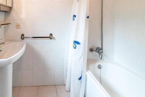 y baño con bañera blanca y lavamanos. en Fener de Dalt 842 Apartamento con terraza, en Girona
