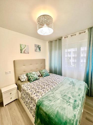 a bedroom with a bed and a chandelier at BLUE PLATAN Apartment in Salou