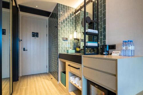 珠海的住宿－珠海横琴雅辰悦居酒店，浴室设有水槽和带瓶子的台面。