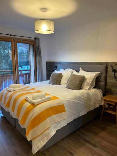 une chambre avec un grand lit à rayures orange et jaunes dans l'établissement Les Chalets de Montriond B101, à Montriond