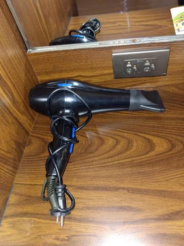 a black hair dryer sitting on a wooden table at Baan Plaifah Khao Yai Hotel in Khao Yai