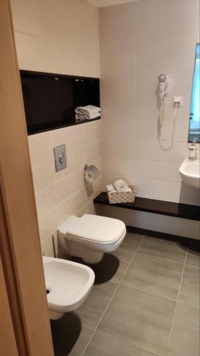 a bathroom with two toilets and a sink at Wellness Apartments in Velence in Velence