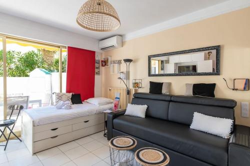 une chambre avec un lit, un canapé et un miroir dans l'établissement Superbe studio bord de mer avec terrasse & piscine, à Cannes