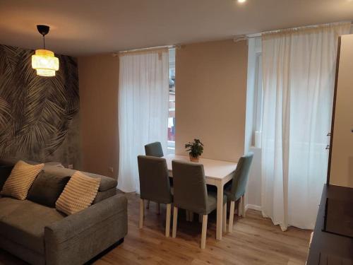 un salon avec une table, des chaises et un canapé dans l'établissement la loge nature de la friche DMC, à Mulhouse