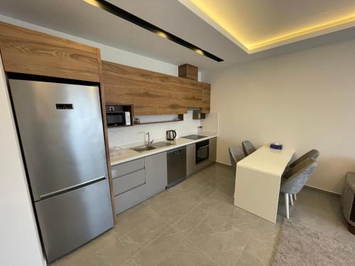 a kitchen with a stainless steel refrigerator and a table at SA Apartments! 1bd Flat 300m to the Beach in Alanya
