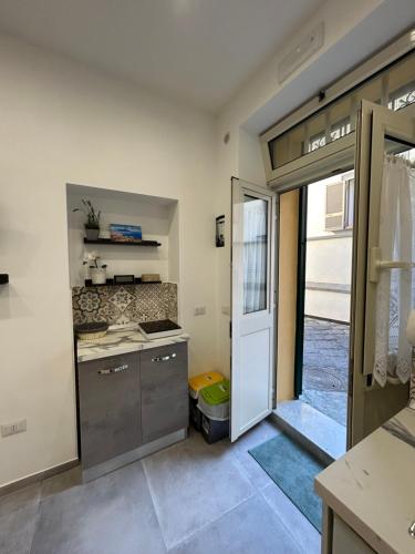 a kitchen with a door open to a room at Sermoneta10 in Naples