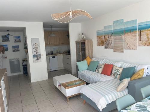 un salon avec un canapé et une cuisine dans l'établissement Appartement de charme T3 avec petit jardin et parking, à La Teste-de-Buch