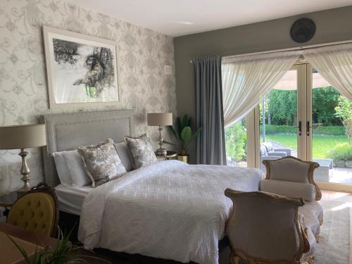1 dormitorio con cama blanca y ventana en Ballybur Lodge, en Grange