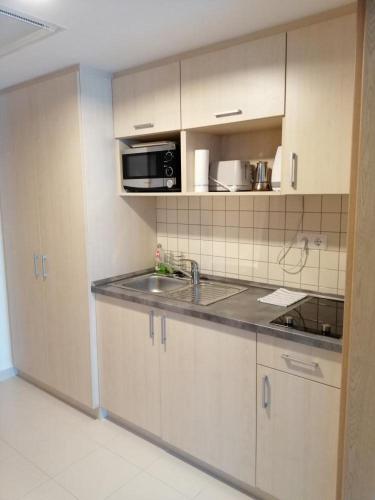 a kitchen with a sink and a microwave at Wellness Apartments in Velence in Velence