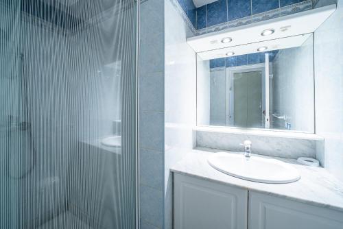 une salle de bain blanche avec un lavabo et une douche dans l'établissement L'Abri Côtier Radieux - Plage à 5min à pied, à Canet