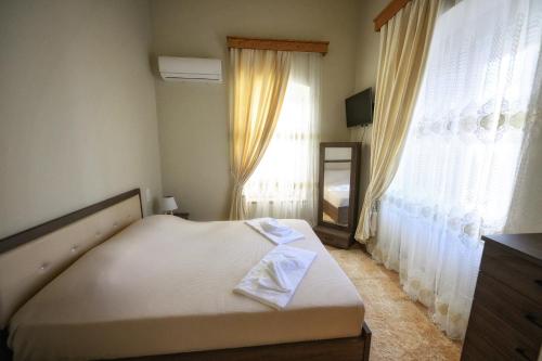 a bedroom with a bed and a large window at STEMA Kalymnos in Kalymnos