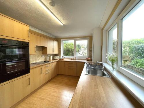 a large kitchen with a sink and a window at Pass the Keys Beautiful House With Stunning Views Kirkcudbright in Kirkcudbright