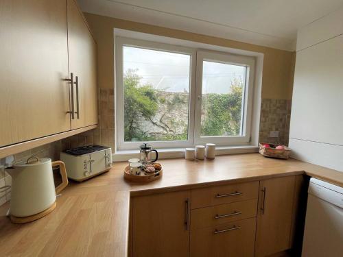 a kitchen with a counter with a window in it at Pass the Keys Beautiful House With Stunning Views Kirkcudbright in Kirkcudbright