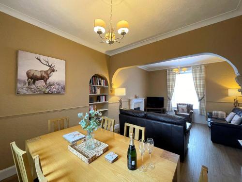 a dining room with a table with a deer on the wall at Pass the Keys Beautiful House With Stunning Views Kirkcudbright in Kirkcudbright