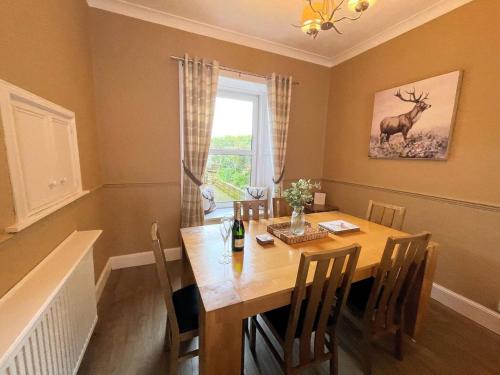 a dining room with a table and a deer on the wall at Pass the Keys Beautiful House With Stunning Views Kirkcudbright in Kirkcudbright