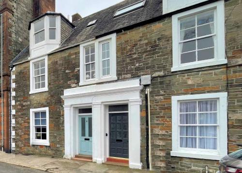 a brick house with white windows and a door at Pass the Keys Beautiful House With Stunning Views Kirkcudbright in Kirkcudbright