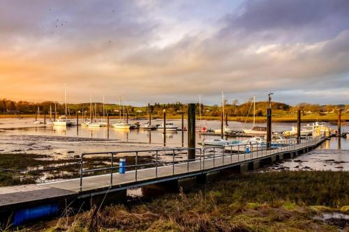 a dock with boats docked in a marina at Pass the Keys Beautiful House With Stunning Views Kirkcudbright in Kirkcudbright