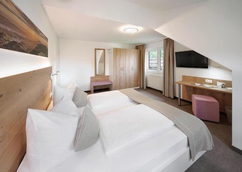 Habitación de hotel con cama blanca y escritorio en Hotel Gasthof Engel, en Appenweier