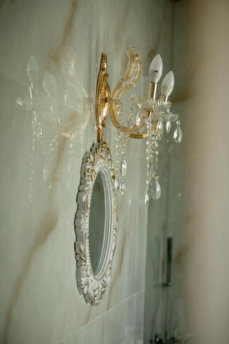a mirror hanging on a wall with a chandelier at STEMA Kalymnos in Kalymnos