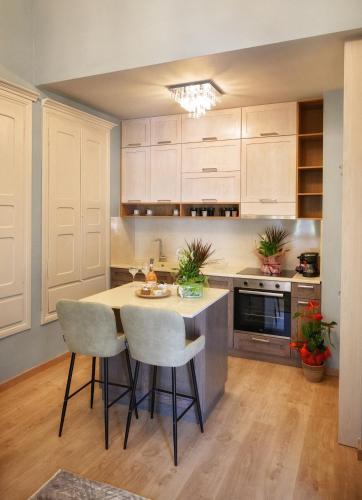 a kitchen with white cabinets and a table and chairs at STEMA Kalymnos in Kalymnos