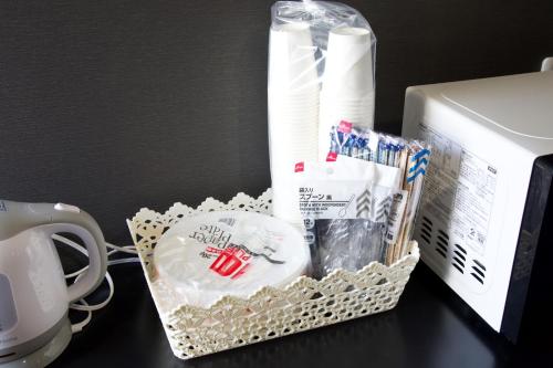 a basket on a desk next to a microwave at smart room tokyo koiwa city in Tokyo