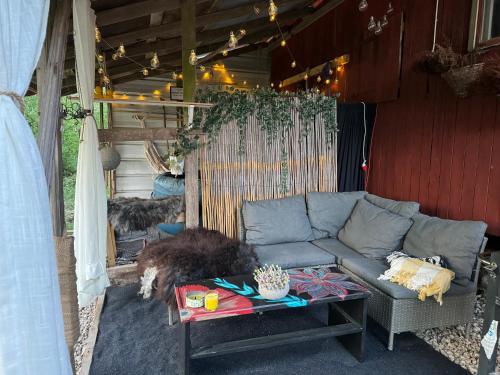 een woonkamer met een bank, een hond en een tafel bij The Hideout Log Cabin near Klarälvsbanan and swimming area in Munkfors