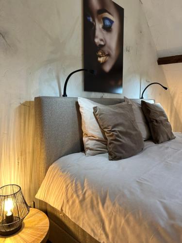 a bed with a picture of a woman on the wall at Brabantse Hoeve in Volkel