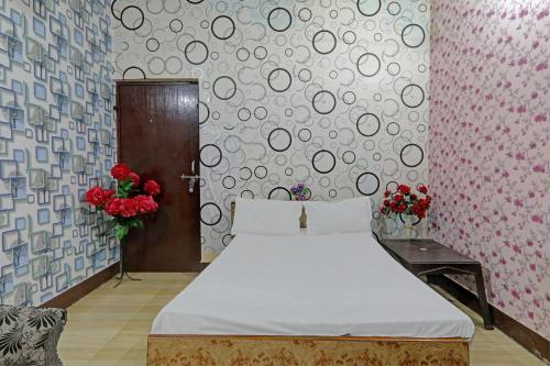 1 dormitorio con 1 cama y una pared con flores en OYO The Home en Lucknow