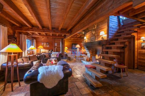 a living room with leather furniture and a wooden ceiling at Chalet Tré la Vieux - Happy Rentals in Chamonix-Mont-Blanc
