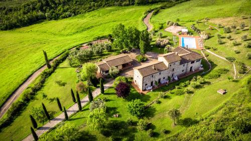 una vista aérea de una casa en un campo verde en Agriturismo LUCERTOLA, en Montecatini Val di Cecina