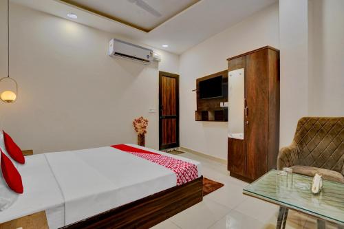 a bedroom with a bed and a chair and a table at Flagship Hotel Orchid in Ludhiana