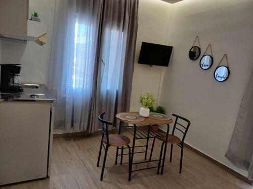a small table and chairs in a kitchen with a counter at Romeos Studios in Agia Marina Nea Kydonias