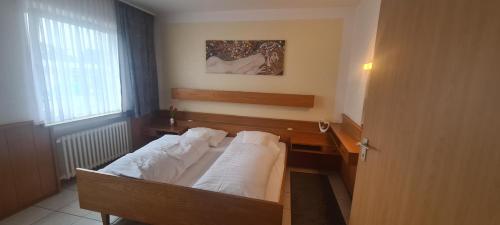 a bedroom with a bed with white pillows on it at Hotel Zur Aue in Wesel