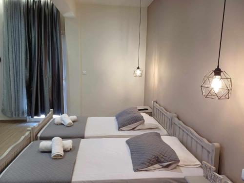 a room with three beds in a row at Romeos Studios in Agia Marina Nea Kydonias