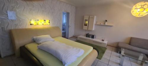 a small living room with a couch and a chair at Hotel Zur Aue in Wesel