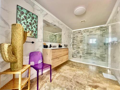 a bathroom with a purple chair and a shower at Macarena House & Chill Out in Benidorm