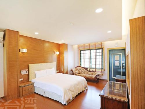 a bedroom with a white bed and a couch at 清境 百里莊園 Baili Manor Cing Jing in Renai