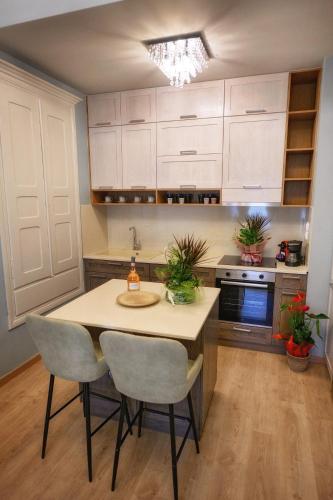 a kitchen with white cabinets and a table and chairs at STEMA Kalymnos in Kalymnos