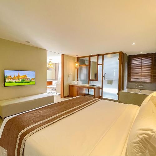 a bedroom with a large bed and a bathroom at G Mekong Hotel Phom Penh in Phnom Penh