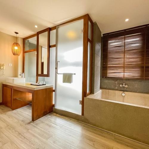 a bathroom with a shower and a sink and a tub at G Mekong Hotel Phom Penh in Phnom Penh