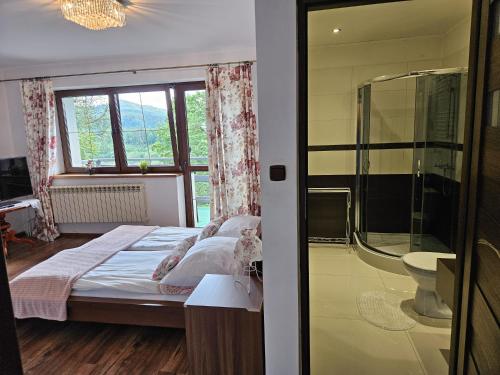 a bedroom with a bed and a glass shower at Willa Olivia in Wisła