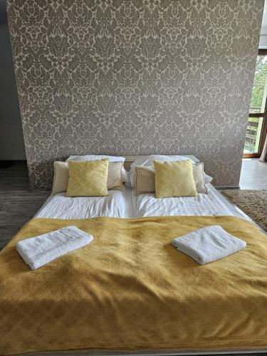 a large bed with two pillows on top of it at Willa Olivia in Wisła