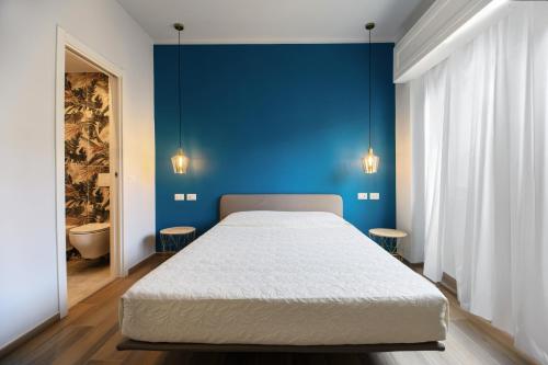 a bedroom with a large bed with a blue wall at Bianca Elegance Rooms in La Spezia