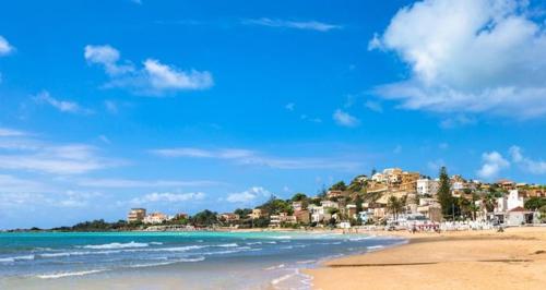 a beach with a group of people on the water at Casa Vacanze La Casetta di Zinu' in Porto Empedocle
