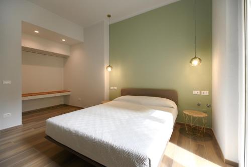 a bedroom with a white bed and a table at Bianca Elegance Rooms in La Spezia